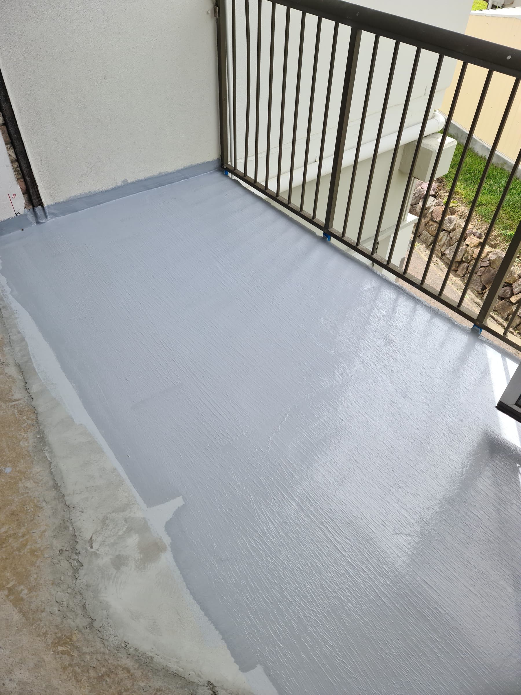 Balcony floor mid-coat with grey liquid waterproofing membrane
