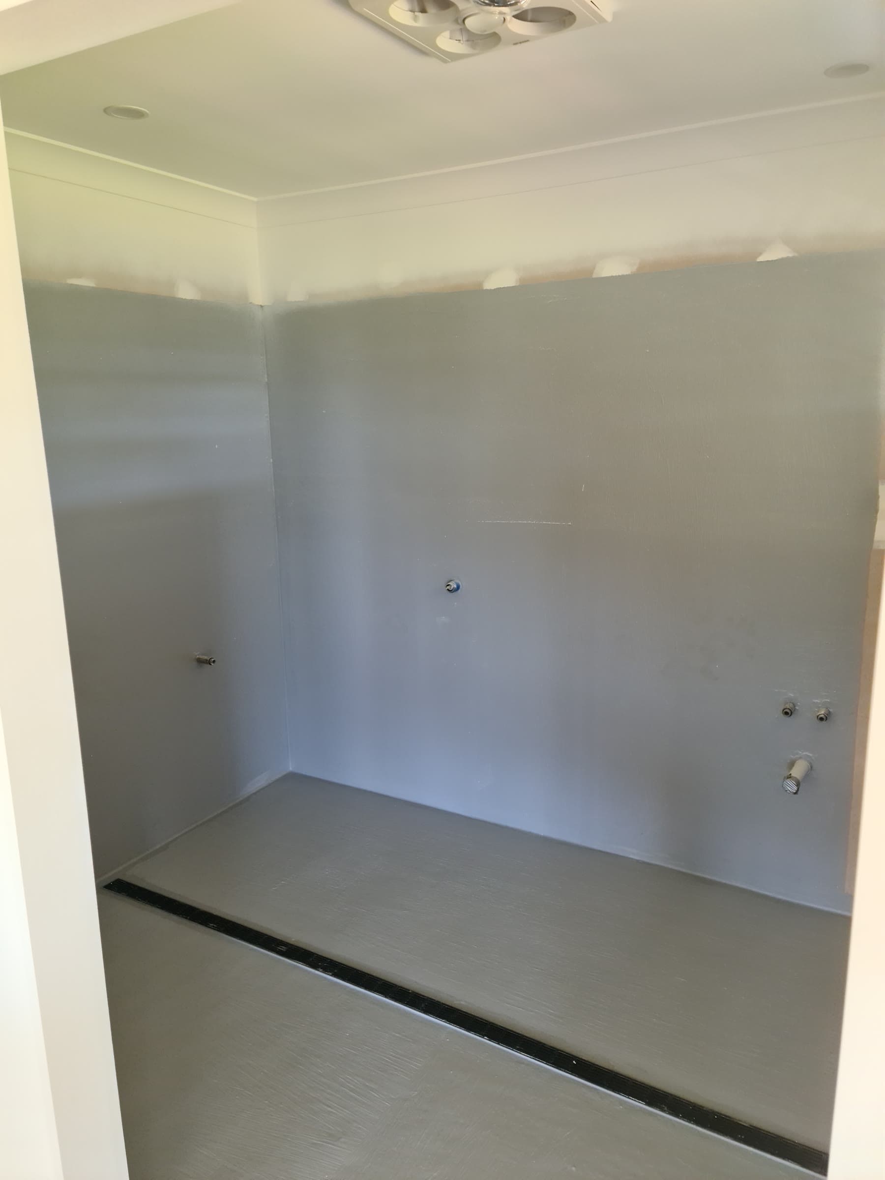 Bathroom wet area fully tanked with grey membrane and linear drain